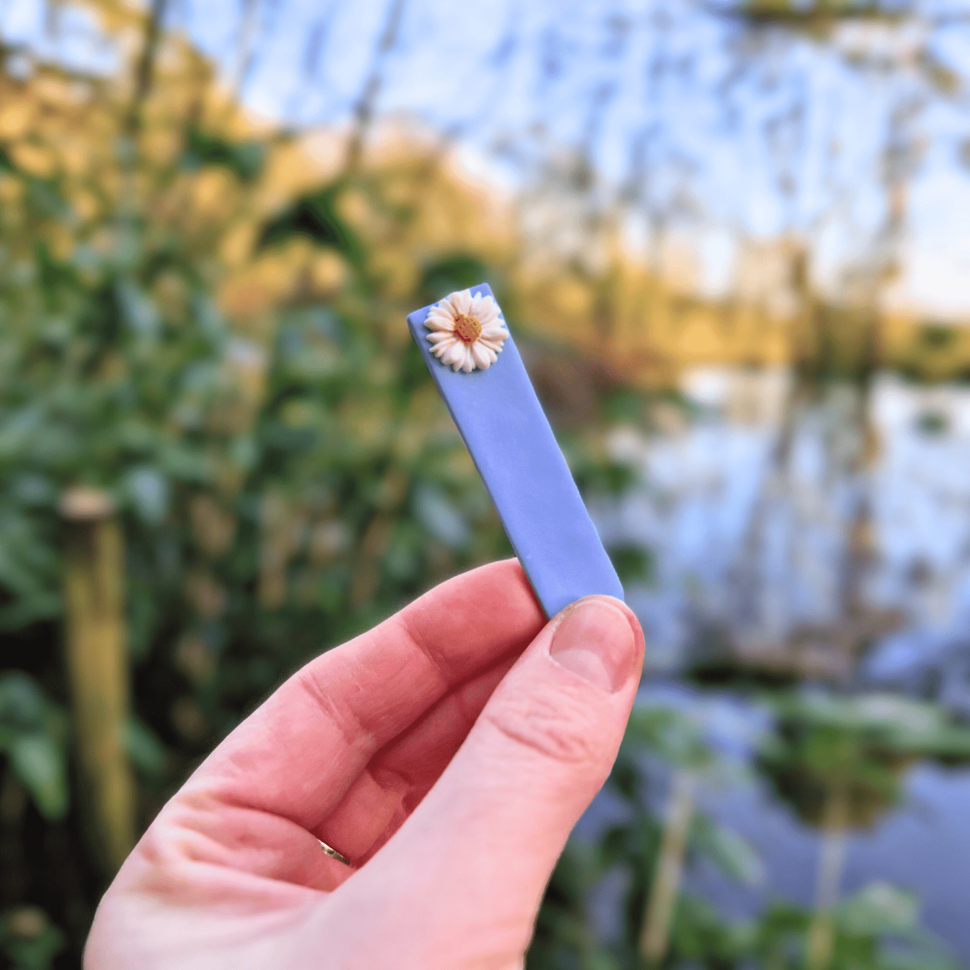 Daisy Decorative Blue Plant Tag with Hand for Scale Thumbnail.