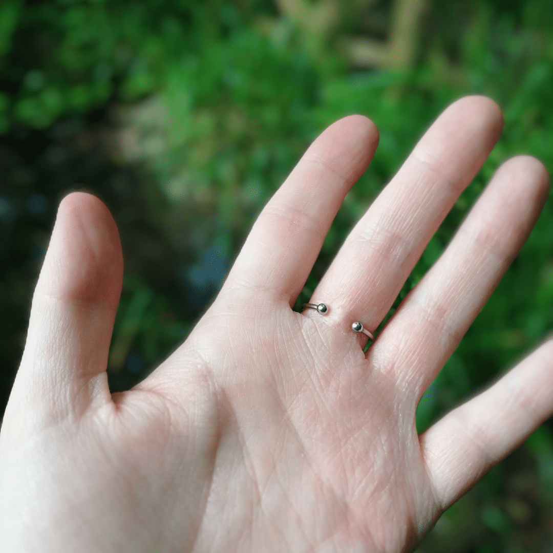 Back of our adjustable Sunflower ring with hand for scale.