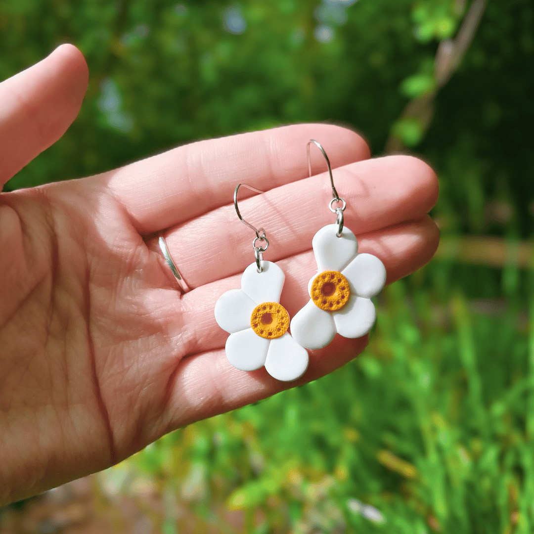 Half Daisy Simplistic Hook Earrings in Hand for Scale.
