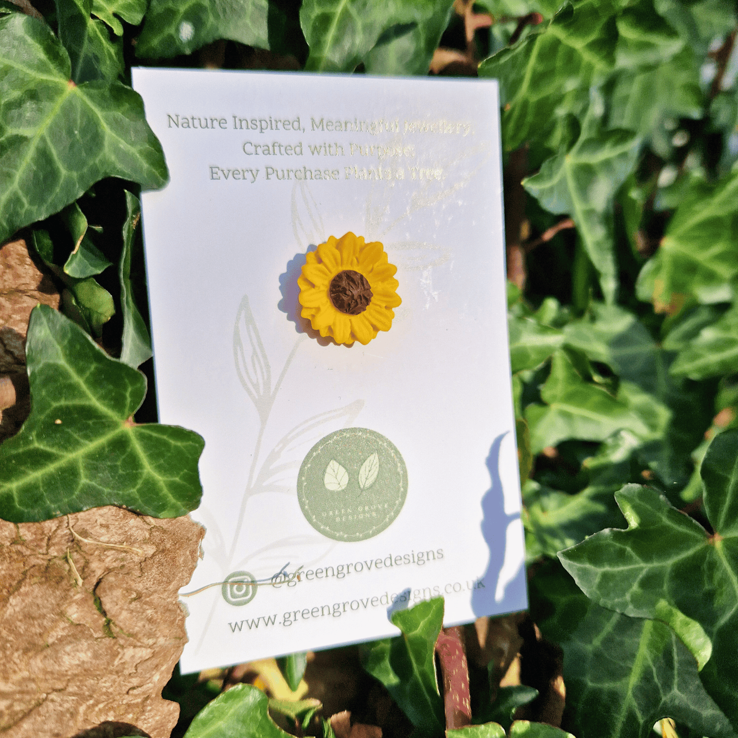 Close up image of intricate and detailed polymer clay Sunflower pin with nature background.