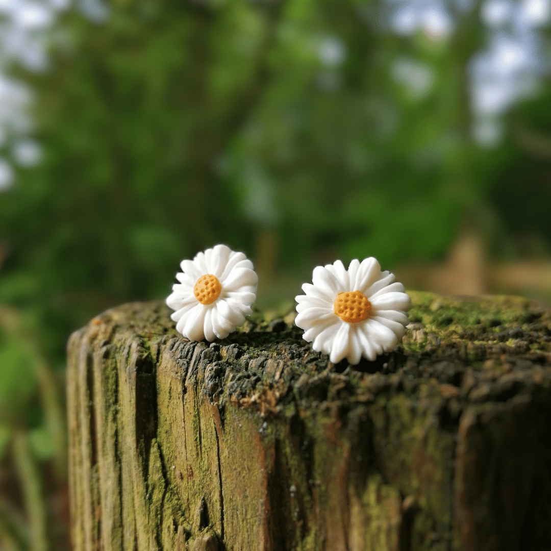 Close up Image of our Intricate Minimalistic Daisy Stud Earrings Displayed on a Wooden Post.