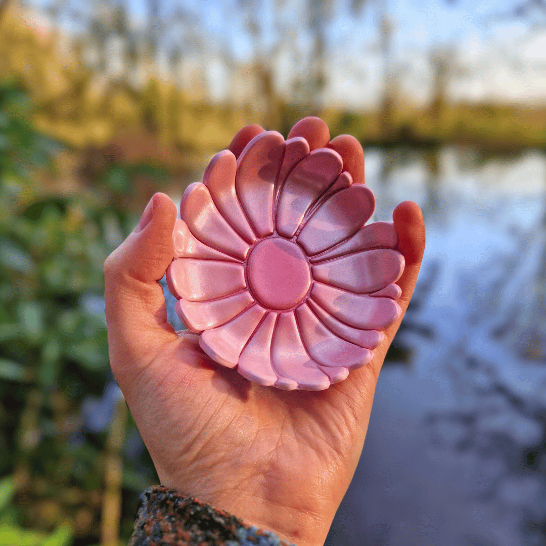 Our Metallic Pink Springtime Daisy Trinket Dish in Hand for Scale with Nature Background in Dorset.
