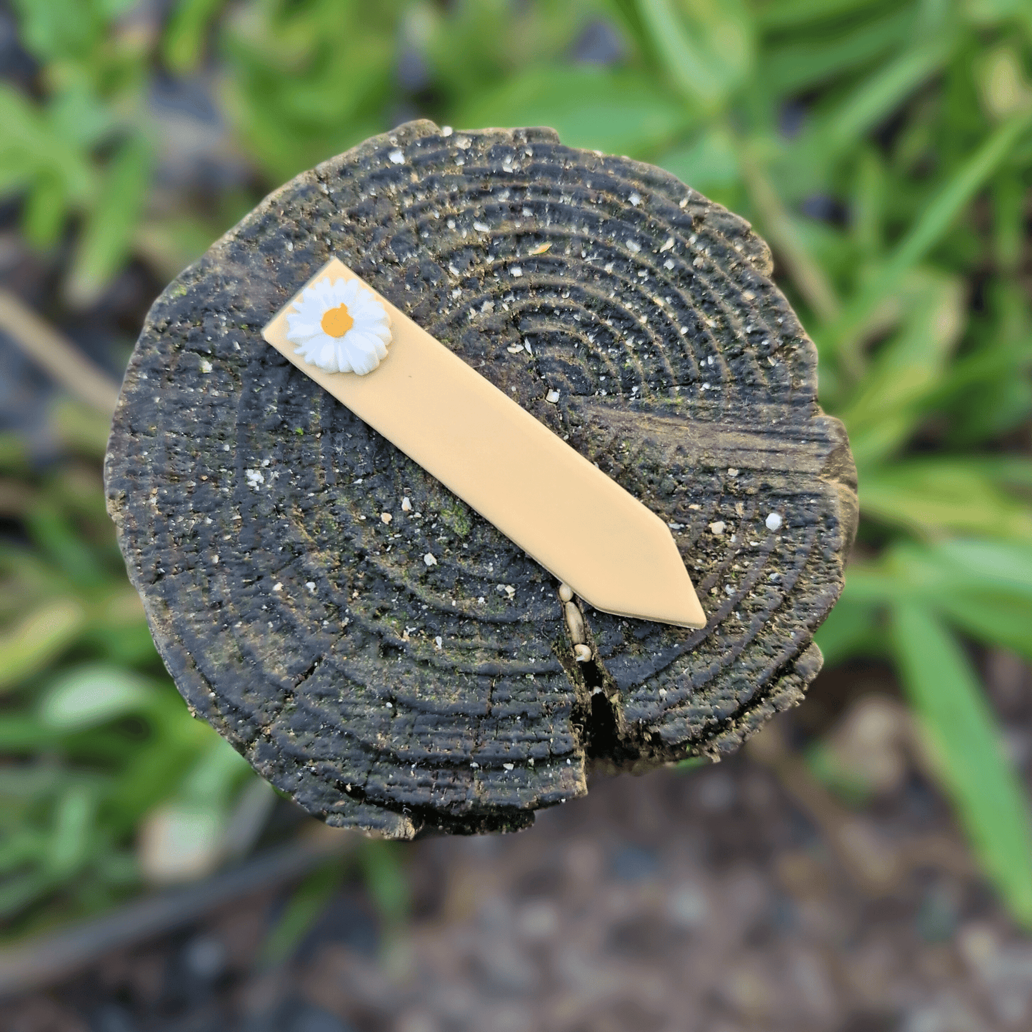 Polymer Clay Decorative Daisy Plant Tag on Wooden Post in Nature.