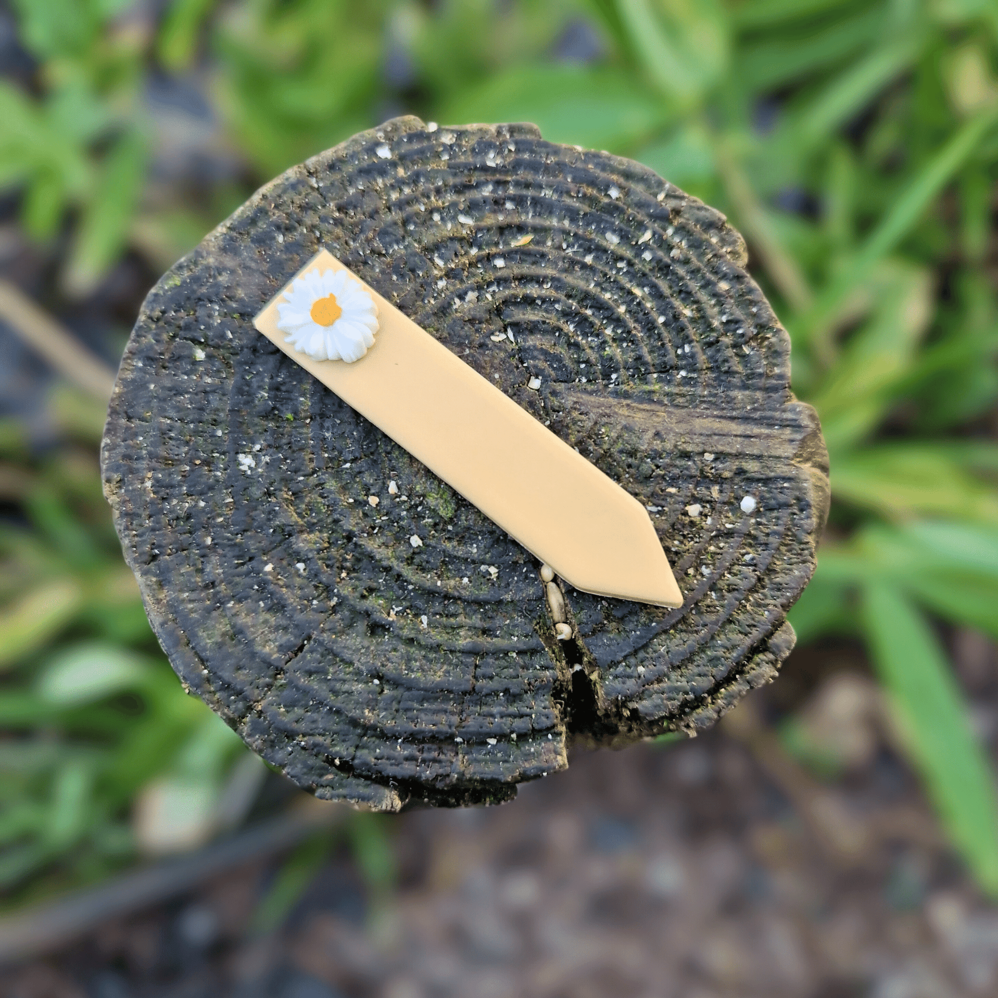 Polymer Clay Decorative Daisy Plant Tag on Wooden Post in Nature.