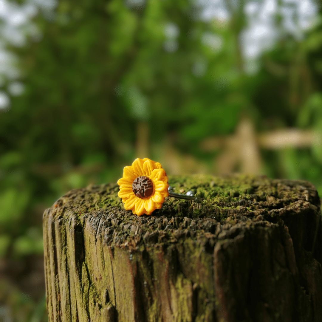 Adjustable hand crafted sunflower ring, side view on wooden post.