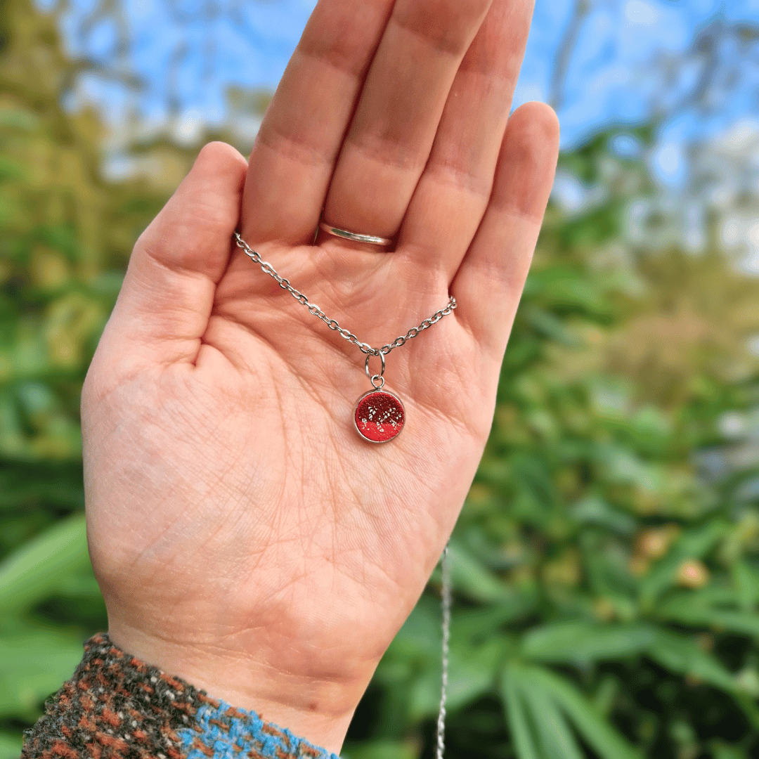 Hand for Scale Image of the Zero Waste Pendant Tray Necklace Hand Crafted in Dorset With Nature Background.