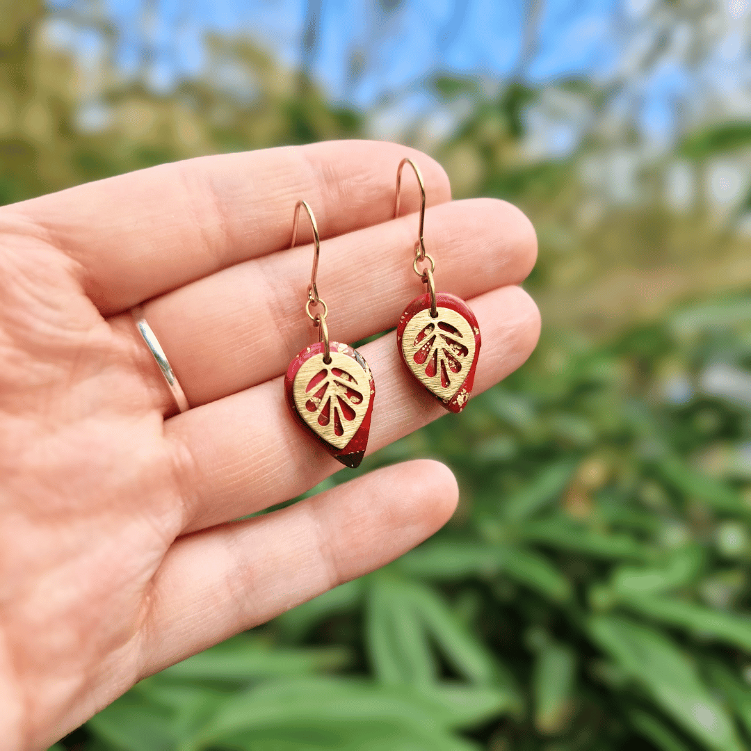 Hand for Scale Image for Option 1 of the Zero Waste Reds and Gold Tear Leaf Hooks with Nature Background.
