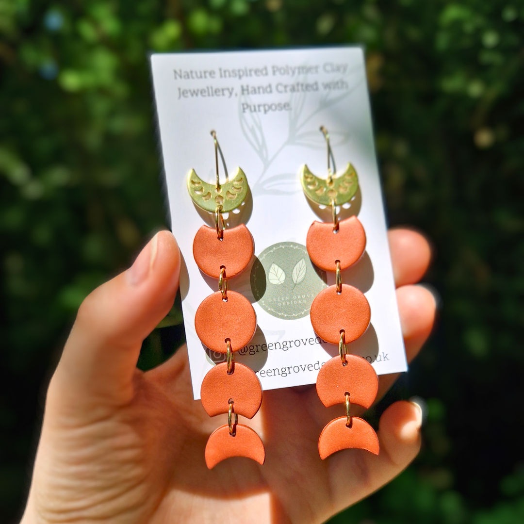 Packaging Image for the Copper and Gold Moon Phase Drop Earrings with Nature Background