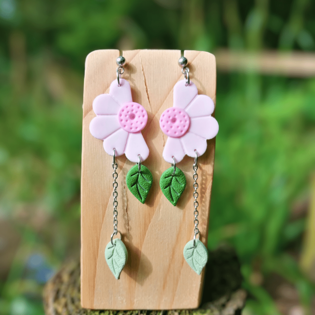 Pink Half Daisy Polymer Clay Drop Studs Displayed on a Wooden Stand.