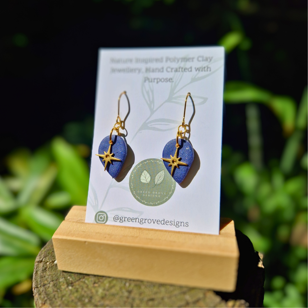 Glitter Blue North Star Teardrop Earrings Displayed on Green Grove Designs Branding