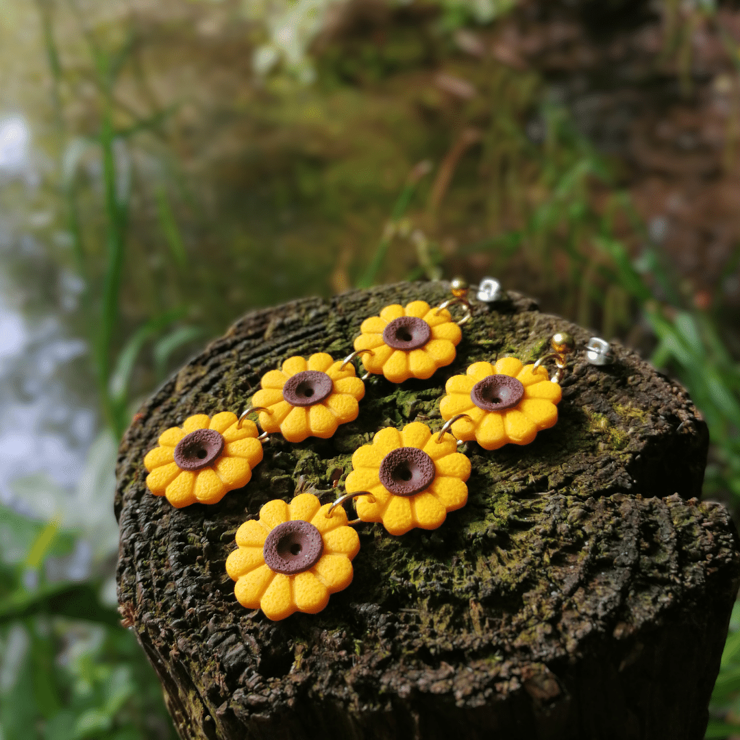 Bright and bold trio Sunflower drop studs on a wooden post with nature background.