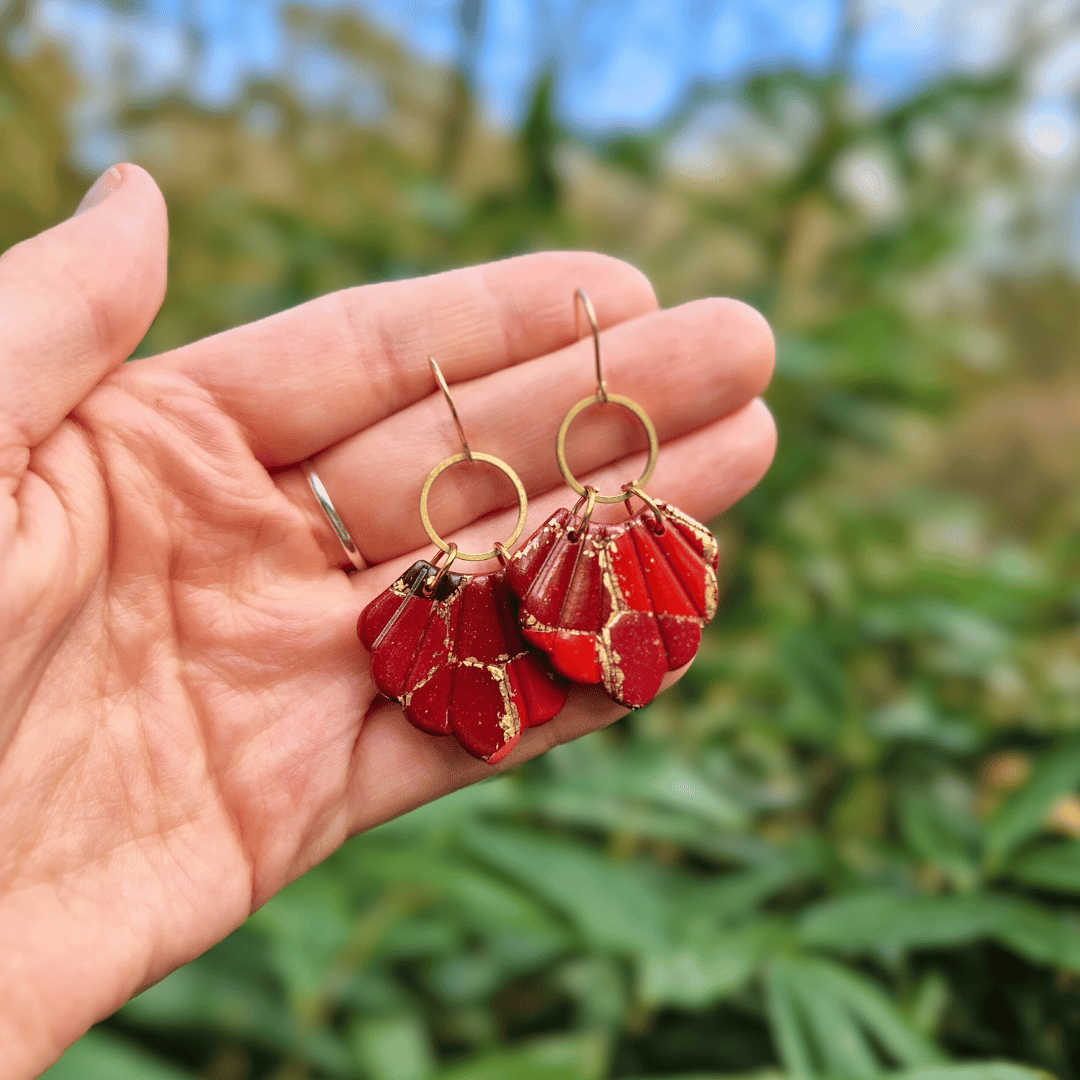 Hand for Scale Image for Option 2 of the Reds and Golds Zero Waste Shell Earrings with Nature Background.