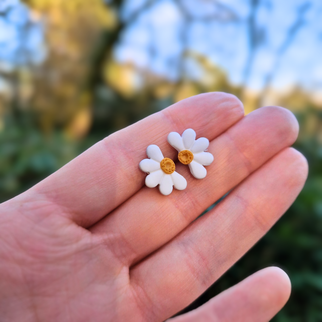 Close up Image of our Mini Half Daisy Studs in Hand for Scale.